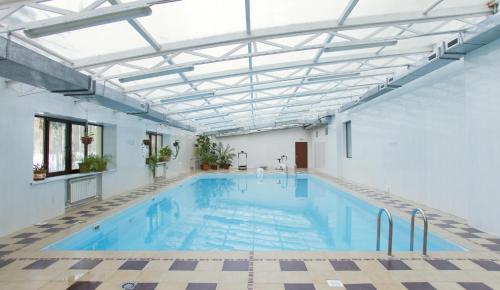 una gran piscina cubierta con techo de cristal en Sanatory Nekhama, en Kazán