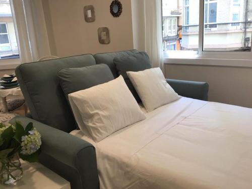 un letto con due cuscini sopra in una stanza di HyP - Esquina Primavera a La Coruña