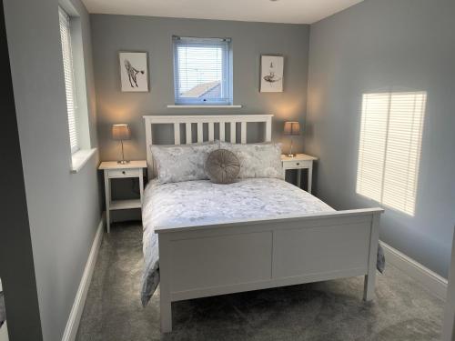 1 dormitorio con 1 cama blanca y 2 mesitas de noche en Newly Refurbished Entire Apartment - South Gosforth, Newcastle, en High Heaton