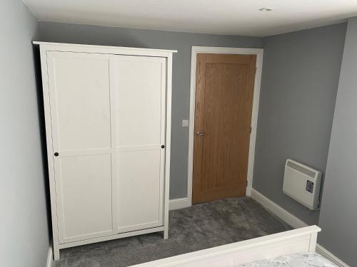 een kamer met een witte kast en een deur bij Newly Refurbished Entire Apartment - South Gosforth, Newcastle in High Heaton