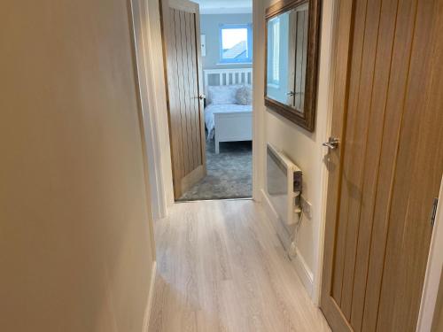 un couloir menant à une chambre avec un miroir dans l'établissement Newly Refurbished Entire Apartment - South Gosforth, Newcastle, à High Heaton