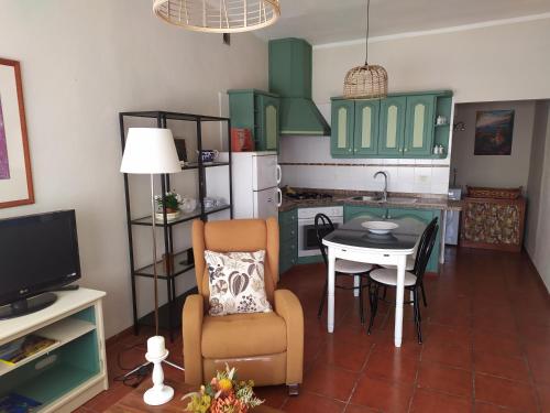 TimijiraqueにあるAmanecerのキッチン(緑のキャビネット、テーブル、椅子付)