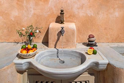 a fountain with a bowl of fruit and a bowl of oranges at Villa Amalia by Thireon in Oia
