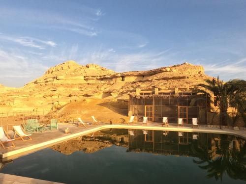 a resort with a swimming pool and a mountain at Talist Siwa in Siwa