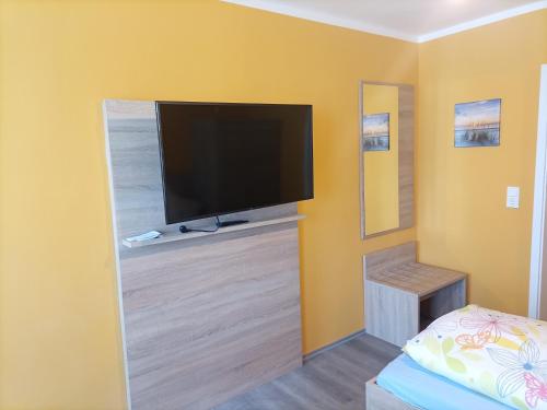 a living room with a flat screen tv on a wall at Hotel An der Karlstadt in Bremerhaven