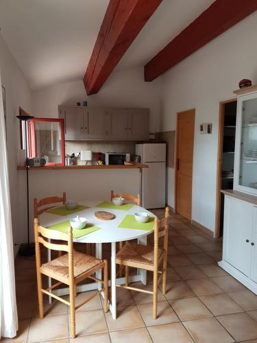 une cuisine avec une table et des chaises dans une pièce dans l'établissement Petite maison entre Sanary et Bandol, à Sanary-sur-Mer