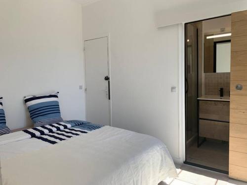 - une chambre blanche avec un lit et une salle de bains dans l'établissement Résidence de l’Hippodrome, à Deauville