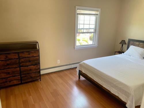 sypialnia z łóżkiem, komodą i oknem w obiekcie The Village - Entire 2nd Floor apartment with parking 