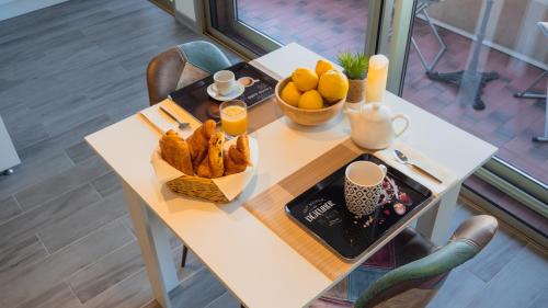 una mesa con una cesta de pan y naranjas. en Menton Centre 2 pièces Climatisée, Balcon et Proche Gares en Menton