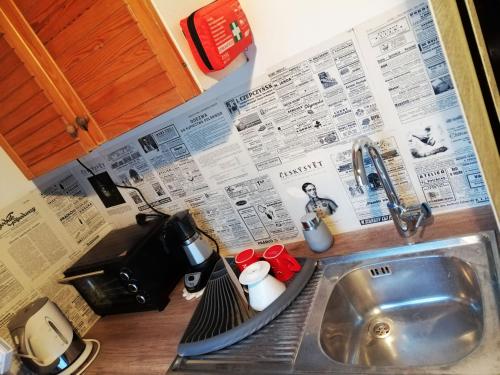 a kitchen counter top with a sink and a counter sidx sidx at Art Apartament Puszczykowo in Puszczykowo