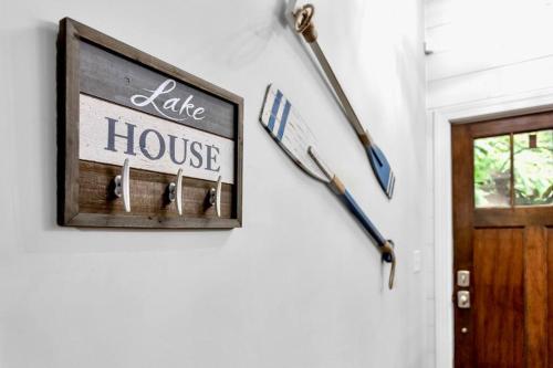 a sign on a wall with a bat and a house at Lakefront, Saltwater Pool, Backyard Oasis, Private Dock, Home Gym in Flowery Branch