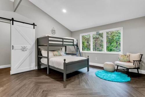 a bedroom with a bunk bed and a chair at Lakefront, Saltwater Pool, Backyard Oasis, Private Dock, Home Gym in Flowery Branch