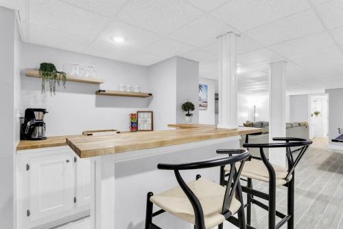 a kitchen with two bar stools at a counter at Lakefront, Saltwater Pool, Backyard Oasis, Private Dock, Home Gym in Flowery Branch