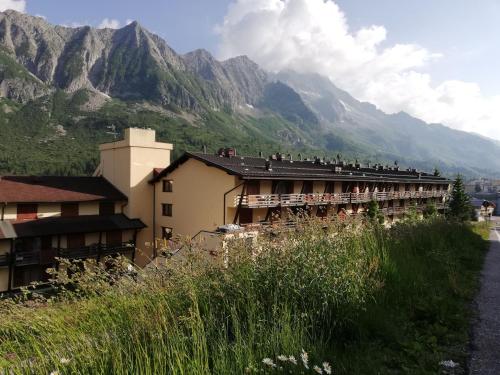 budynek z ludźmi siedzącymi na dachu i górami w tle w obiekcie DONCIO`S Ski Hike & Bike Apartment w mieście Passo del Tonale