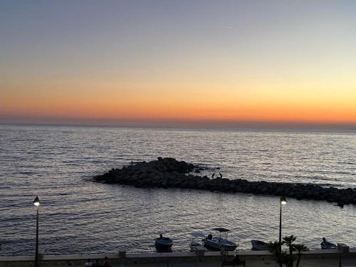 a group of boats on the ocean at sunset at Un Posto al Mare in Santa Maria di Castellabate