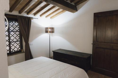 a bedroom with a bed and a table and a window at Villa Betta by Mmega in Lugnano
