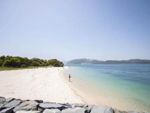 a person walking on a beach with the water at Villa Fati With Pool by Vacationy in Troia