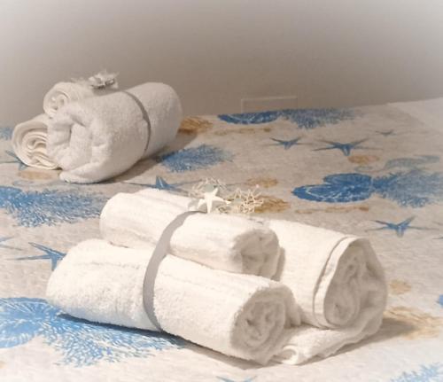 stos ręczników leżący na łóżku w obiekcie B&B Verdi w mieście Brindisi