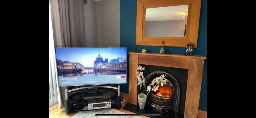 a television in a living room with a fireplace at Sleeps 8 Snowdonia North Wales Nr Zip World in Tanygrisiau