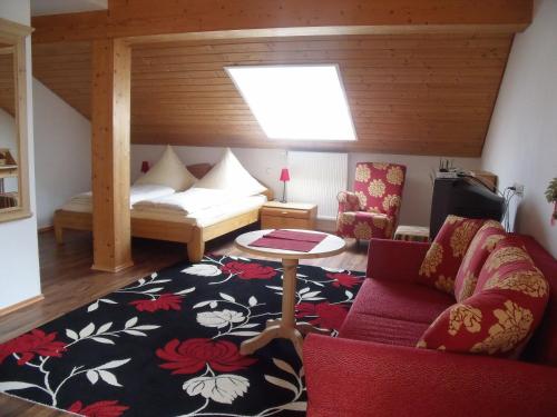 ein Wohnzimmer mit einem Sofa und einem Tisch in der Unterkunft Landhotel Zahn's Weißes Rössle - ruhig schlafen- gut frühstücken - lecker essen in Dietmannsried