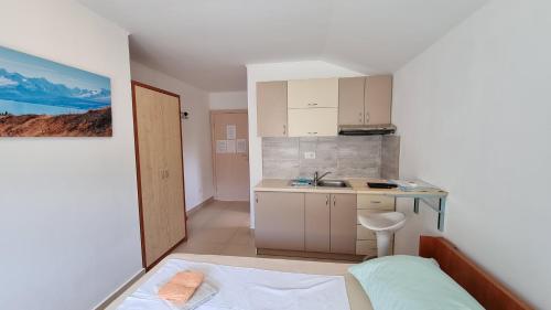 a small kitchen with a bed and a sink at Apartments Bellator in Šilo
