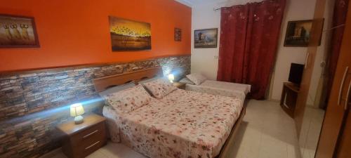 ein Schlafzimmer mit einem Bett und einer Ziegelwand in der Unterkunft Appartamento in Complesso Sonia in Santa Teresa di Riva