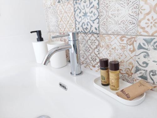 een wastafel met twee flessen essentiële oliën erop bij La terrazza di Elena in Fasano