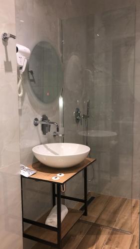 un bagno con lavandino bianco e doccia di F&J Hotel a Sarandë