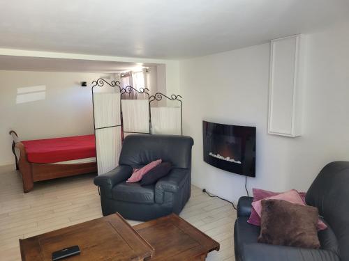 sala de estar con sofá y cama en logement à 50 m de la mer !, en Hermanville-sur-Mer