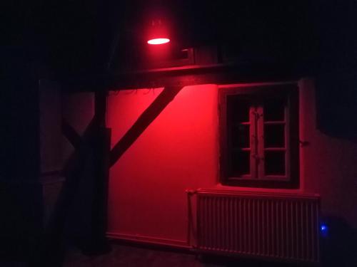 a red light on the side of a building with a window at Art Apartament Puszczykowo in Puszczykowo