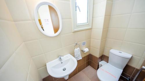 une salle de bain avec des toilettes blanches et un lavabo dans l'établissement Kapparis Holiday Villa 018, à Protaras