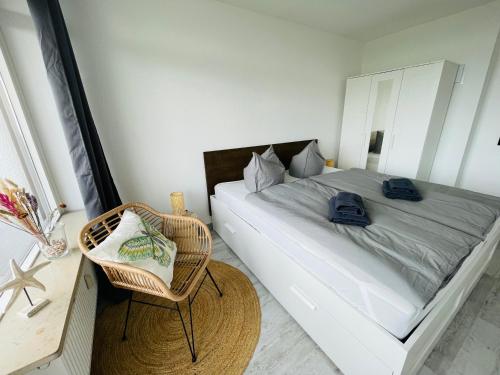 a bedroom with a large bed and a chair at Apartment Fischkoker mit Meerblick und Pool in Dahme
