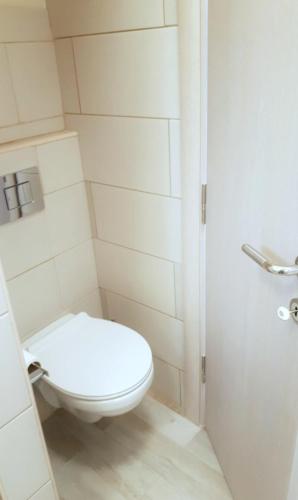 a white bathroom with a toilet and a shower at River Casa in Ledine