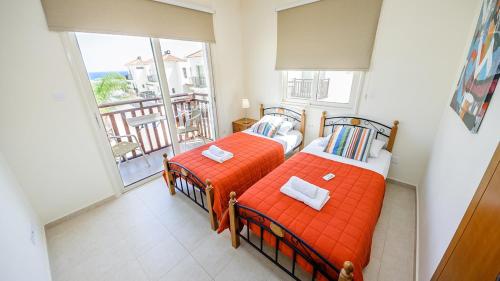 deux lits dans une chambre avec balcon dans l'établissement Kapparis Holiday Villa 018, à Protaras