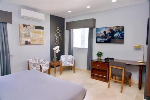 a bedroom with a bed and a desk and a table and chairs at Rio Suites in Tijuana