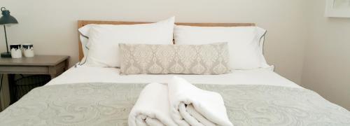 a bedroom with a bed with white towels on it at Hilton Cove Beach House in Melkbosstrand