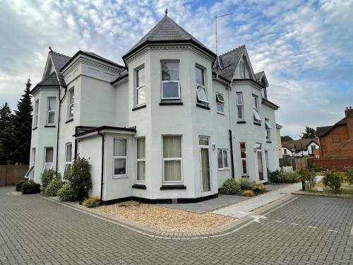 a large white house with a gambrel roof at Stylish One Bedroom Central Bournemouth Flat in Bournemouth