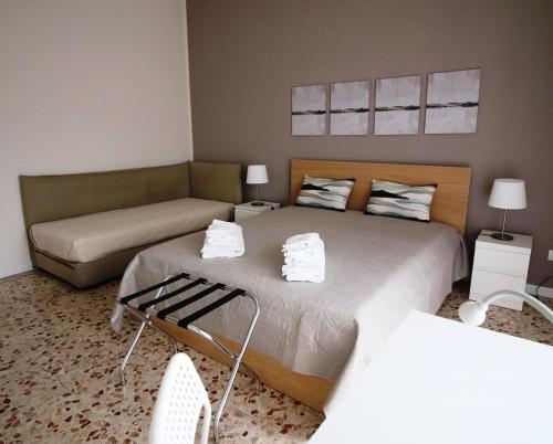 a bedroom with two beds and a couch at Giuffrida Apartment Rooms in Catania