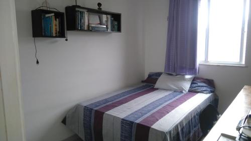 a small bed in a room with a window at Piatã apartamento com Clube in Salvador