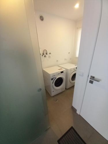a bathroom with a washing machine and a washer and dryer at Casa Aveiro Modern House in Aveiro