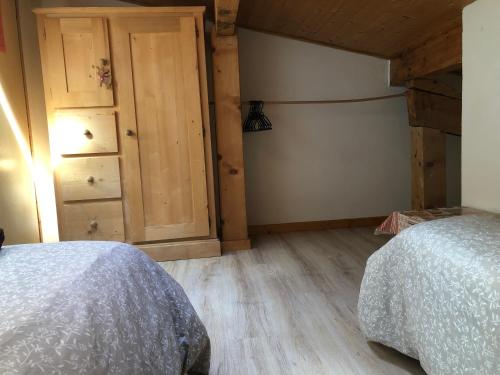 a bedroom with a bed and a wooden floor at Central Hostel Chatel in Châtel