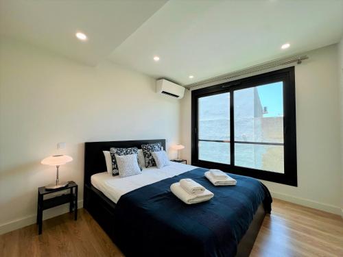 a bedroom with a bed with a large window at Faro Design 1 by Homing in Faro