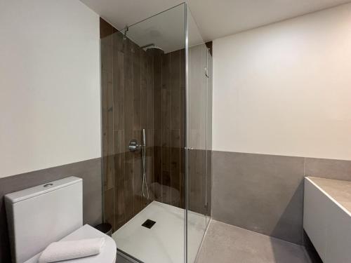 W łazience znajduje się toaleta i przeszklony prysznic. w obiekcie Faro Design 1 by Homing w Faro