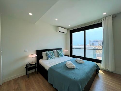 a bedroom with a bed and a large window at Faro Design 2 by Homing in Faro
