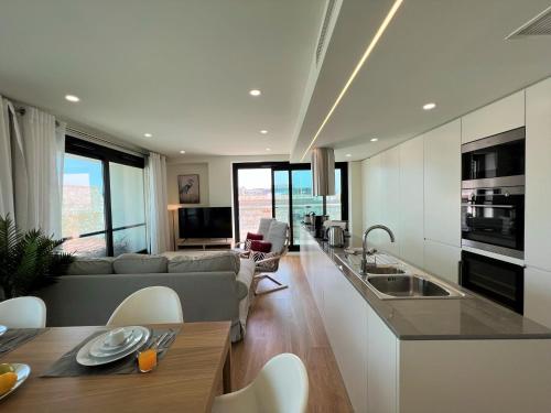 a kitchen and living room with a couch and a table at Faro Design 2 by Homing in Faro