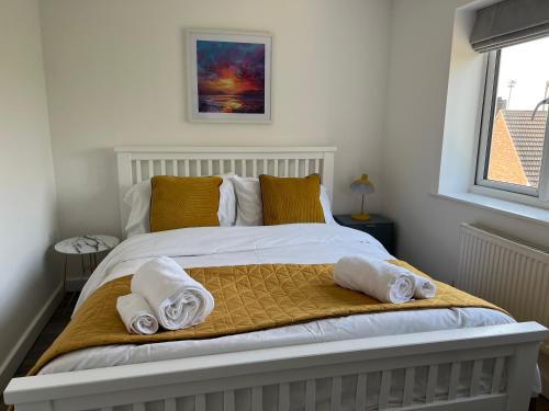 um quarto com uma cama com toalhas em The Aldridge 2 Bedroom Apartment with FREE Parking em Ibstock