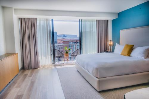 a bedroom with a bed and a large window at Hotel Madera in Washington