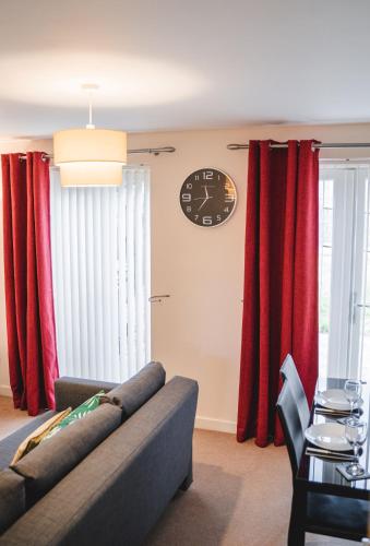 a living room with red curtains and a couch at Snapos Apartments - Tudor Close in Carbrook