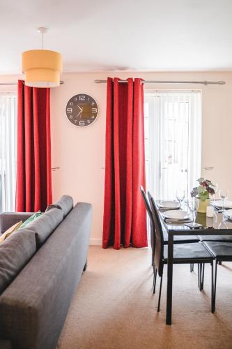 a living room with a table and red curtains at Snapos Apartments - Tudor Close in Carbrook