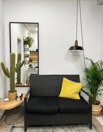 un sofá negro en una sala de estar con plantas en Precioso apartamento en el corazón de Madrid, en Madrid